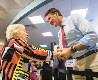  ?? KENDALL WARNER/STAFF ?? Gov. Glenn Youngkin talks with city councilwom­an Pat Woodbury during an early voting rally in Newport News on Wednesday.