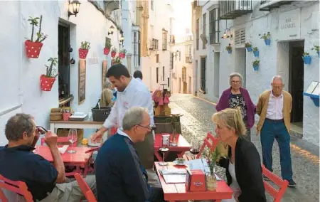  ?? RICK STEVES ?? A cobbled street in Arcos de la Frontera serves as an alfresco dining spot.