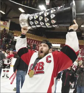  ?? Cp pHoto ?? New Brunswick Varsity Reds captain Cameron Critchlow holds the University Cup over his head after his team beat the Saskatchew­an Huskies in yesterday’s gold-medal game.