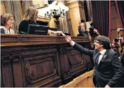  ??  ?? Carles Puigdemont, above, cast his vote for independen­ce, prompting scenes of jubilation in Barcelona, top, as the spectre of a Spanish crackdown loomed large
