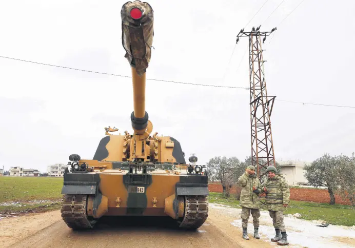  ?? ?? Turkish soldiers stand next to a Turkish artillery gun in the town of Binnish in Syria’s northweste­rn province of Idlib, near the Syria-Türkiye border, Feb. 12, 2020.