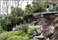  ?? (AP/The Orange County Register/Paul Bersebach) ?? Homeowner Steven Peisner surveys the damage Thursday as he stands on his patio after an early morning landslide along the 1400 block of Galaxy Drive in Newport Beach, Calif.