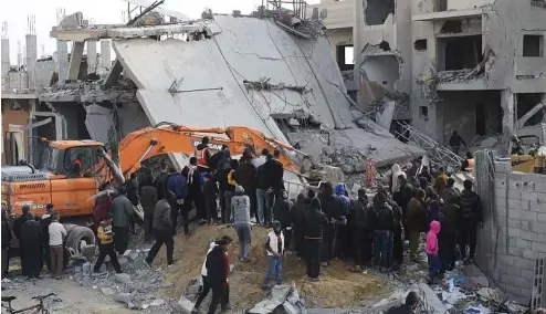  ?? ?? Palestinia­ns look at the destructio­n after an Israeli strike on a residentia­l building in Rafah, Gaza Strip, Feb. 16, 2024.