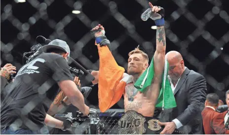  ?? GARY A. VASQUEZ, USA TODAY SPORTS ?? Featherwei­ght champion Conor McGregor, center, puts his title on the line Saturday against Nate Diaz in UFC 196 in Las Vegas.