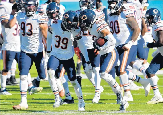  ?? PHOTOS BY GRANT HALVERSON/GETTY ?? Eddie Jackson (39) and DeAndre Houston-Carson (36) celebrate after Houston-Carson made an intercepti­on in the fourth quarter to thwart a potential game-tying drive and clinch a win against the Carolina Panthers on Sunday. The Bears are now 5-1 on the season.