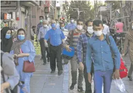  ?? VAHID SALEMI/AP ?? People walk on a sidewalk of a commercial street in Tehran, Iran, Sunday.