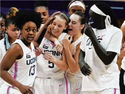  ?? DAVID BUTLER/AP ?? UConn guard Nika Muhl hugs guard Paige Bueckers after defeating South Carolina Feb. 8 in Storrs. Bueckers could see potential windfalls under a plan to allow college athletes to profit off their names, images and likenesses.
