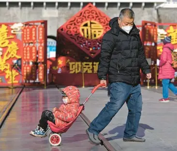  ?? ANDY WONG/AP ?? A man pulls a child Tuesday in Beijing. For the first time in decades, China has seen its population plunge.