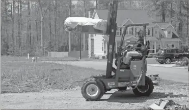  ?? Doug Walker ?? A forklift driver hauls a load to a residentia­l developmen­t in Battle Farm subdivisio­n off Old Summervill­e Road on Tuesday.