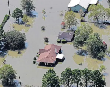  ?? [AP PHOTO] ?? Homes are surrounded by floodwater­s in the aftermath of Hurricane Harvey on Friday near Beaumont, Texas.