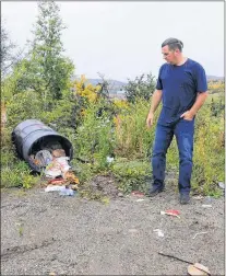  ?? MIKE POWER/THE AURORA ?? Jim Dobbin of Labrador City gets ready to start cleaning up some of the garbage strewn about in front of the Legion.