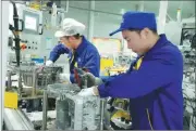  ??  ?? Technician­s from Shengrui Transmissi­on Corp install components in the world’s first front-engine, front-wheel drive 8-gear automatic transmissi­on on a production line.