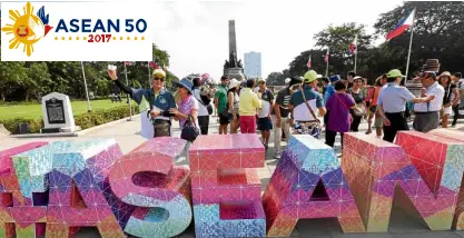  ??  ?? LOCO OVER LOGO Tourists mill around and take selfies at Rizal Park with the Asean logo.