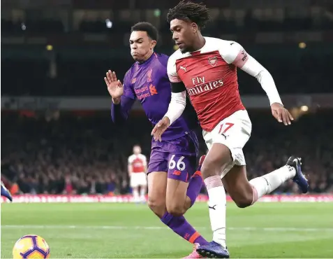  ??  ?? Arsenal’s Nigerian striker Alex Iwobi ( right) contests the ball with Liverpool’s English defender, Trent Alexander-arnold, during the English Premier League match at the Emirates Stadium in London, yesterday.