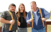  ??  ?? AllPoints Services’ Jeff Solomon (left), Megan Padua and Steve Wilson are honored with yardstick suspenders at a Benefit Homes Project event for going above and beyond for charity.