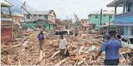  ?? STR/AFP/GETTY IMAGES ?? Residents look at damage Wednesday caused by Hurricane Maria the day before in Roseau, Dominica. Maria smashed into the eastern Caribbean island Tuesday, and winds and rain from the storm also hit territorie­s still reeling from Irma.