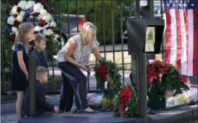  ?? DAVID J. PHILLIP — THE ASSOCIATED PRESS ?? Tiffany Utterson, right, and her children, from left to right, Ella, 11, Ian, 10 and Owen, 8, place a wreath outside the gated community entrance to the home of George H.W. Bush Sunday in Houston. Bush is returning to Washington as a revered political statesman, hailed by leaders across the political spectrum and around the world as a man not only of greatness but also of uncommon decency and kindness. Bush, died late Friday at his Houston home at age 94, is to be honored with a state funeral at National Cathedral in the nation’s capital on Wednesday, followed by burial Thursday on the grounds of his presidenti­al library at Texas A&amp;M.