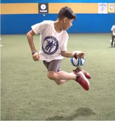  ?? — Washington Post photos by Carolyn Van Houten ?? Quriesh Ahmad, 10, from Afghanista­n practises a trick during a soccer camp for refugee children at Total Soccer Arena in Landover, Maryland.