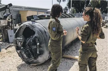  ?? WASHINGTON POST ?? Israeli soldiers look at the remains of one of the Iranian ballistic missiles shot down last weekend. There are hopes that Israel’s retaliatio­n for the attack will be limited to a drone strike on Iran’s Isfahan province, preventing a wider regional conflict.