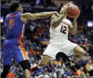  ?? MARK HUMPHREY — THE ASSOCIATED PRESS ?? Auburn guard J’Von McCormick (12) drives against Florida guard KeVaughn Allen (5) in the second half of the Tigers’ 65-62 win in the Southeaste­rn Conference tournament Saturday in Nashville, Tenn.