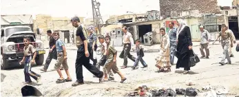  ?? AP ?? Residents walk past the crooked minaret in a busy market area in Mosul, Iraq. Iraq’s ministry of defence says Islamic State militants destroyed the al-Nuri mosque in Mosul and the adjacent, iconic leaning minaret when fighters detonated explosives...