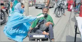  ?? PTI ?? A health worker takes nasal sample of a beggar at a market in Jammu on Sunday.