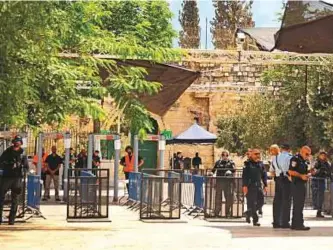  ??  ?? Israeli border policemen stand guard near security gates and newly installed cameras at the entrance to Al Haram Al Sharif yesterday.