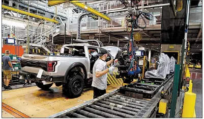  ??  ?? AP A worker installs seats in a F-150 pickup in September at the Ford Rouge assembly plant in Dearborn, Mich. Factory output rose in October despite a drop in auto production.