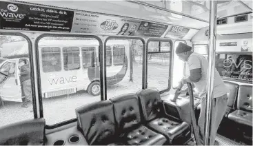  ?? Jon Shapley / Houston Chronicle ?? Jessie Jackson, a mechanic’s helper at The Wave, details a bus in preparatio­n for the weekend rush. The eight vehicles that make up The Wave fleet keep Jackson busy.