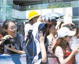  ?? — IC ?? Enthusiast­ic fans jostle with each other for a good position at the front to take photos of their idol Zhu Xingjie, a contestant in “Idol Producer,” in a commercial event in Shenzhen, Guangdong Province.