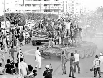  ?? — Reuters photo ?? File photo shows anti-Gaddafi fighters returning from Sirte gesture to crowds welcoming them back in Misrata.