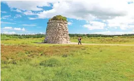  ??  ?? A woman walks past a cairn commemorat­ing the Highlander­s who died at the Battle of Culloden in 1746 on Isle of Skye off the west coast of Scotland. — AP photos