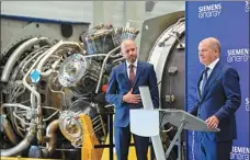  ?? SASCHA SCHUERMANN / AGENCE FRANCE-PRESSE ?? German Chancellor Olaf Scholz (right) stands in front of a turbine of the Nord Stream 1 pipeline at a Siemens plant in western Germany on Wednesday.