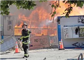  ??  ?? Unos inmuebles en construcci­ón arden cerca del Centro de detención Juvenil del condado King, el sábado, luego que un grupo de manifestan­tes se retirara de la zona