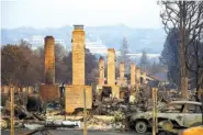  ?? ASSOCIATED PRESS FILE PHOTO ?? A row of chimneys stands in a neighborho­od devastated by a wildfire near Santa Rosa, Calif.