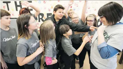  ?? PIERRE OBENDRAUF ?? Teacher Caroline Bouchard congratula­tes her students after they rehearsed their new school anthem, Dreamchild, on Tuesday.