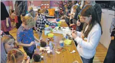  ?? 01_B51brodick­04 ?? Getting their hands dirty, children create Christmas baubles and decorate cookies.