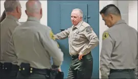  ??  ?? CAPT. Brendan Corbett, who supervises the facility, talks to other sheriff ’s personnel about how detained inmates are handled within the L.A. County jails.