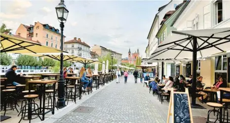  ?? CAMERON HEWITT ?? Ljubljana’s riverfront promenade is lined with quaint boutiques, great restaurant­s and cafés.