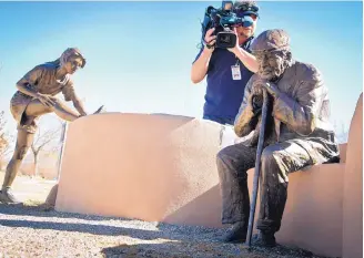  ?? MARLA BROSE/ JOURNAL ?? A television videograph­er films the spot where a bronze dog was stolen from outside the Albuquerqu­e Museum of Art and History. The dog, which was discovered to be missing on Wednesday, is part of a outdoor sculpture by Glenna Goodacre.