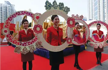  ?? (Bobby Yip/Reuters) ?? FLIGHT ATTENDANTS from Cathay Pacific Airways take part in the upcoming Chinese New Year parade during a rehearsal in Hong Kong last week.
