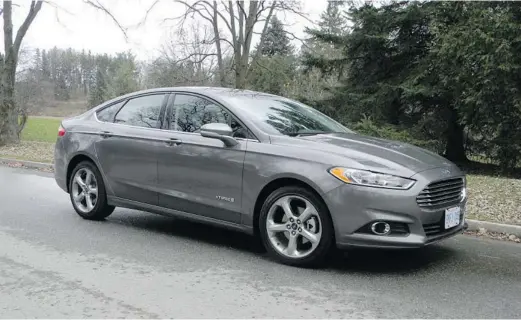  ?? PHOTOS: BRIAN HARPER/POSTMEDIA NEWS ?? With its Aston Martin-like face and sleek, aggressive styling, the 2013 front-wheel-drive Ford Fusion SE Hybrid delivers fuel economy that will please owners.