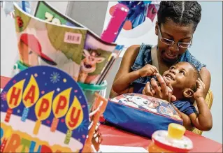  ?? RICHARD GRAULICH PHOTOS / THE PALM BEACH POST ?? Jasmine Johnson, of West Palm Beach, plays with her son Erquis Dixon Jr., 1, at Children’s Services Council’s “Oh What Fun, Look Who’s One!” event Wednesday.