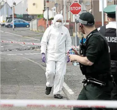  ??  ?? Forensisch­e Experten untersuche­n den Tatort im nordirisch­en Londonderr­y, an dem gestern laut Augenzeuge­nberichten eine bisher unbekannte Person das Feuer eröffnete. Fotos: AFP