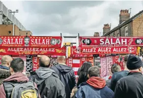  ?? ANDREW TESTA FOR THE NEW YORK TIMES ?? Scarves on sale outside Liverpool’s soccer stadium. Mohamed Salah’s popularity among fans has helped to counter Islamophob­ia.