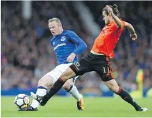  ?? BARRINGTON COOMBS, THE ASSOCIATED PRESS ?? Everton’s Wayne Rooney, left, and Ruzomberok’s Matej Kochan battle for the ball at Goodison Park.