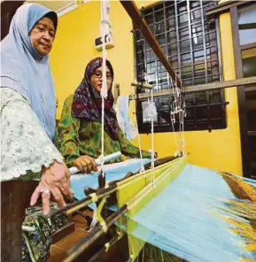  ?? [FOTO ROZAINAH ZAKARIA/BH] ?? Zainab membantu pekerjanya menenun songket.