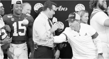  ?? JOE ROBBINS/GETTY ?? Alabama coach Nick Saban tosses oranges to his players after the win over Michigan in the Citrus Bowl on Wednesday.