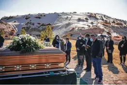  ?? Paul Ratje / AFP via Getty Images ?? Family and friends attend the funeral of Humberto Rosales, a caregiver who died at age 49 from COVID-19 complicati­ons, in Santa Teresa, N.M.