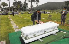  ?? Gabrielle Lurie / The Chronicle 2020 ?? Funeral director Vaughn O. Nixon Sr. arranges the casket of COVID19 victim Tessie Henry, 83, buried April 8 in Colma.